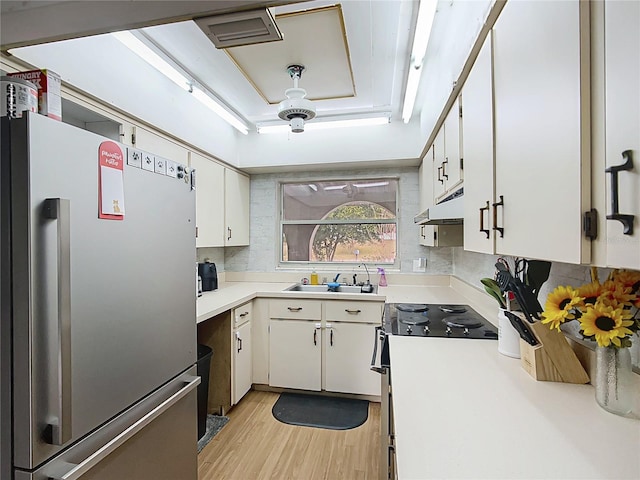 kitchen with white cabinets, light wood-type flooring, sink, and stainless steel appliances