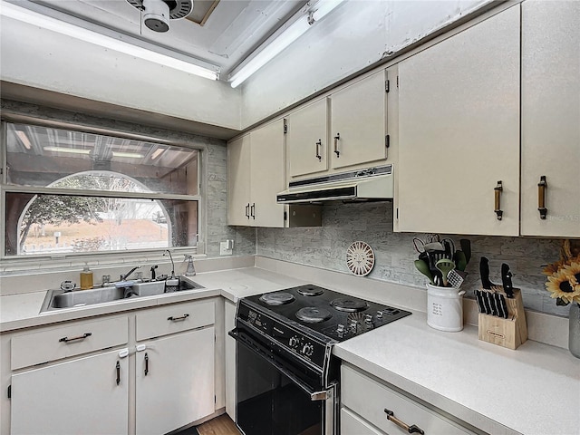 kitchen with backsplash, sink, electric range, and white cabinets