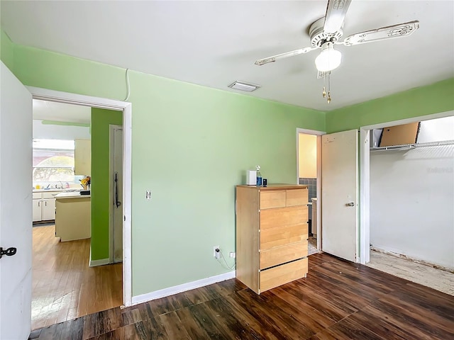 unfurnished bedroom with ceiling fan, dark hardwood / wood-style flooring, a closet, and sink