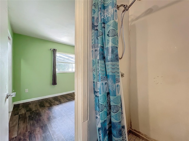 bathroom with a shower with curtain and wood-type flooring