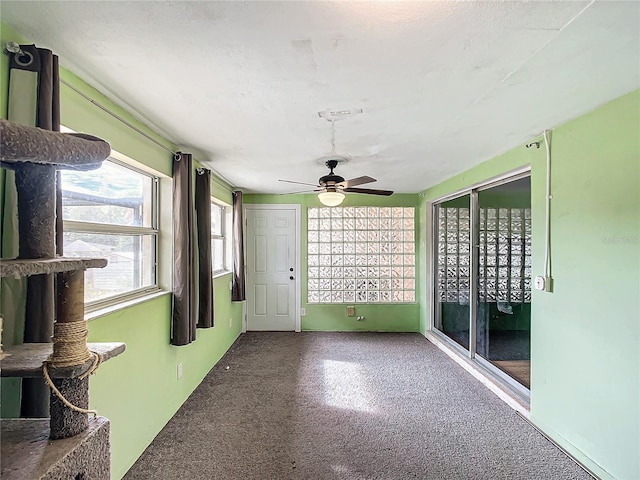 unfurnished sunroom featuring ceiling fan