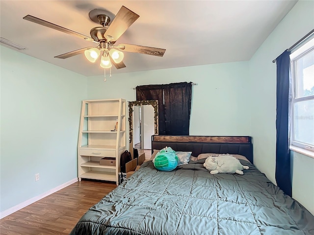 bedroom with ceiling fan and dark hardwood / wood-style flooring