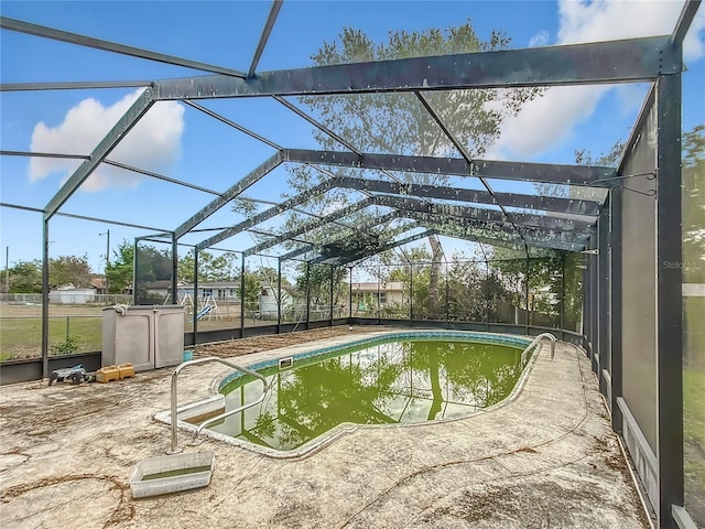 view of swimming pool with glass enclosure and a patio area