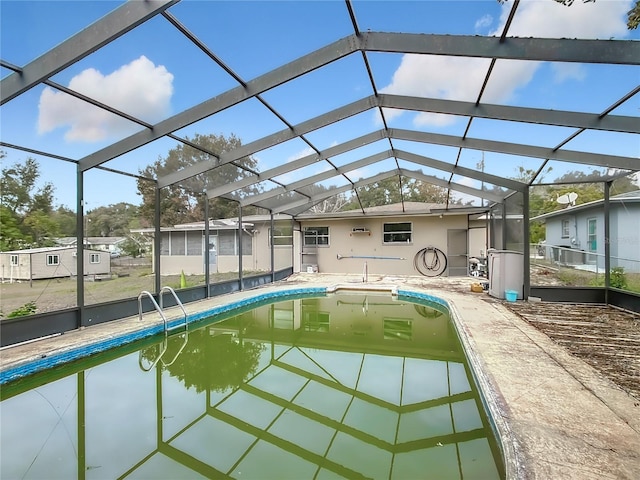 view of swimming pool featuring glass enclosure and a patio area