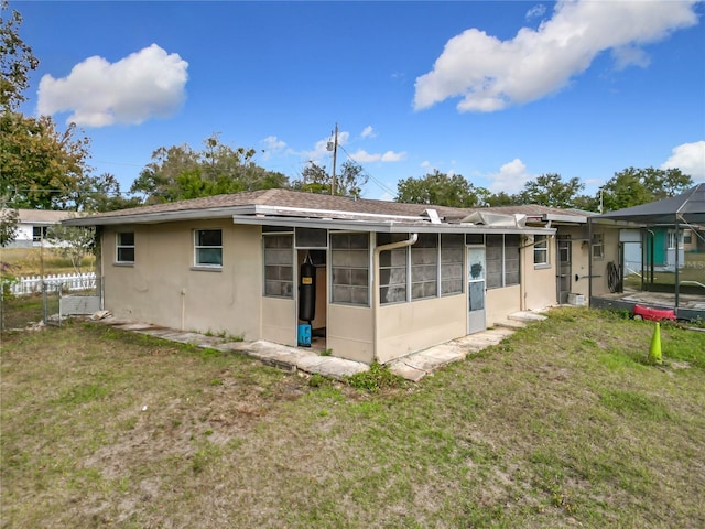 rear view of house featuring a yard