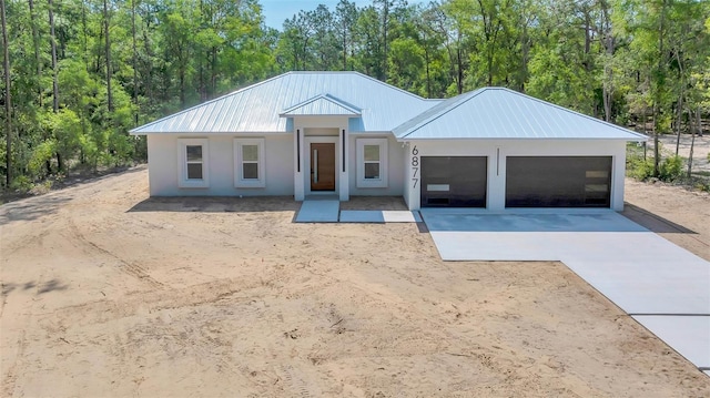 6877 SW 131st Cir, Ocala, FL 34481 - view of front facade featuring driveway, a garage, metal roof, and stucco siding