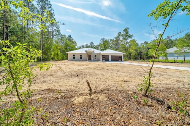 6877 SW 131st Cir, Ocala, FL 34481 - view of front of home with concrete driveway, metal roof, and a garage