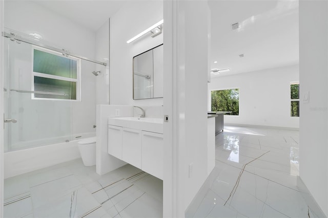 6877 SW 131st Cir, Ocala, FL 34481 - full bathroom featuring vanity, toilet, baseboards, and shower / bath combination with glass door