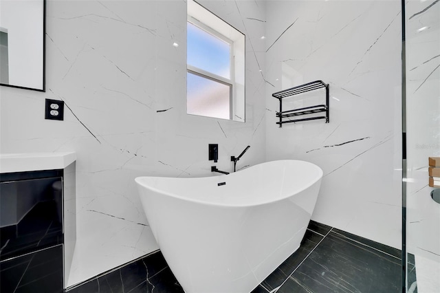 6877 SW 131st Cir, Ocala, FL 34481 - bathroom featuring a freestanding tub, vanity, tile walls, and marble finish flooring