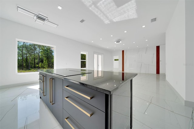 6877 SW 131st Cir, Ocala, FL 34481 - kitchen with modern cabinets, a kitchen island, black electric stovetop, gray cabinetry, and baseboards
