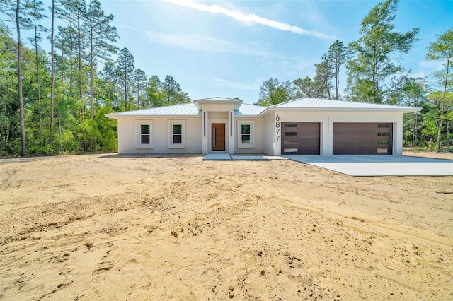 6877 SW 131st Cir, Ocala, FL 34481 - view of front facade featuring a standing seam roof, a garage, metal roof, concrete driveway, and stucco siding