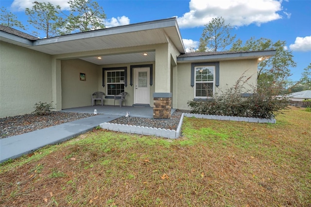 entrance to property featuring a lawn