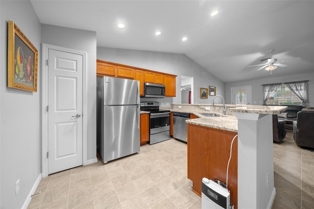 kitchen with sink, light stone counters, vaulted ceiling, kitchen peninsula, and stainless steel appliances