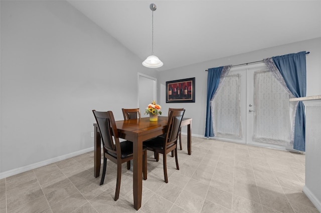 dining area with vaulted ceiling and french doors