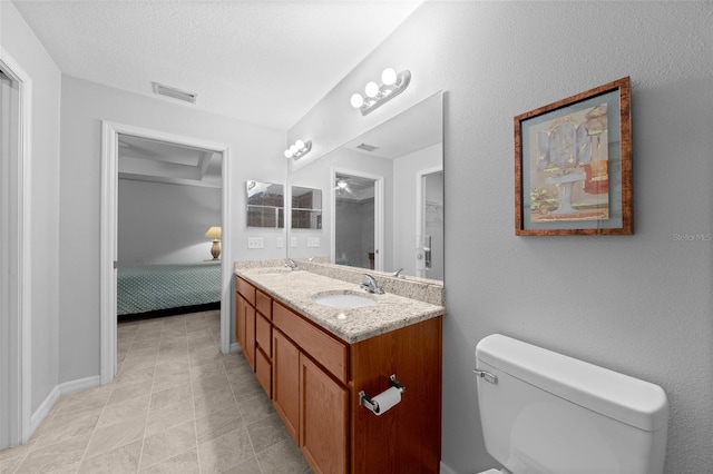 bathroom featuring vanity, a textured ceiling, and toilet