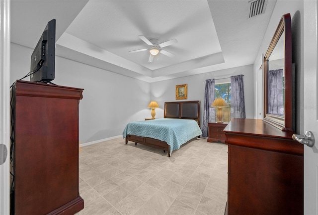 bedroom featuring a raised ceiling and ceiling fan