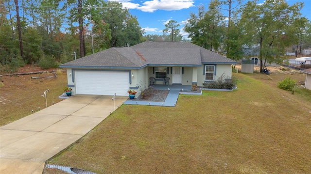 ranch-style home featuring a garage, covered porch, and a front yard