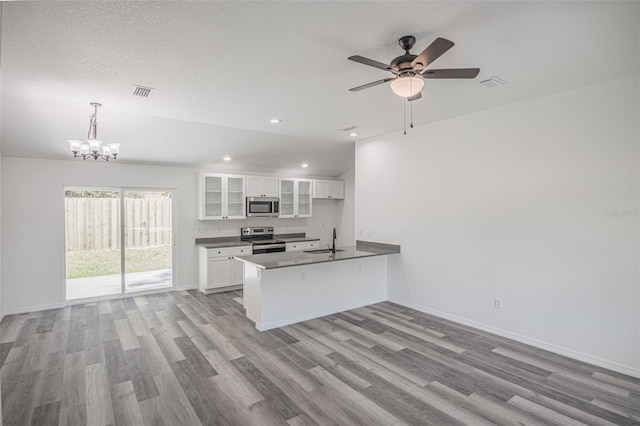 kitchen featuring kitchen peninsula, sink, white cabinetry, hanging light fixtures, and stainless steel appliances