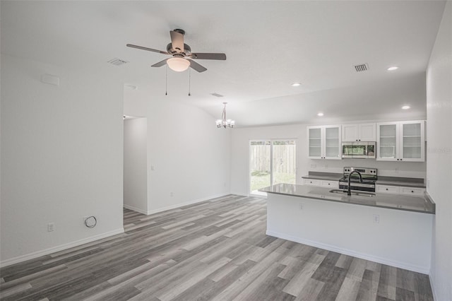 kitchen featuring ceiling fan with notable chandelier, white cabinets, decorative light fixtures, sink, and light hardwood / wood-style flooring