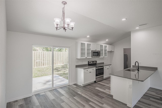 kitchen featuring pendant lighting, kitchen peninsula, sink, white cabinetry, and appliances with stainless steel finishes