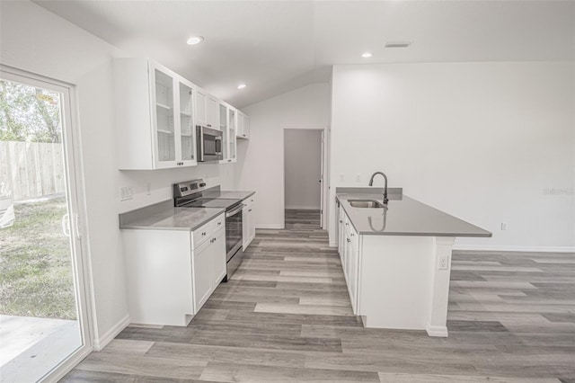 kitchen with white cabinets, a kitchen bar, stainless steel appliances, sink, and kitchen peninsula