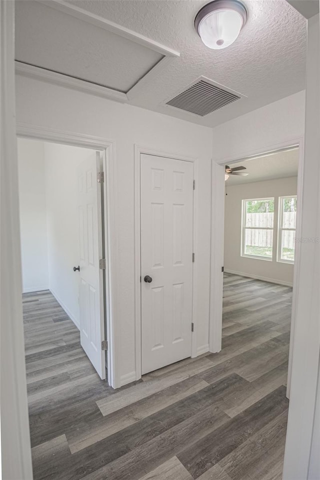 corridor featuring a textured ceiling and dark hardwood / wood-style floors