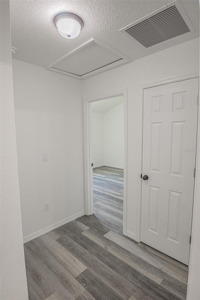 spare room with a textured ceiling and hardwood / wood-style flooring