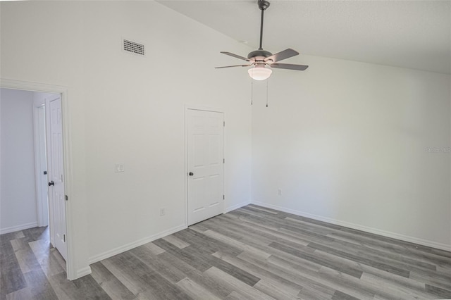 empty room featuring ceiling fan, light hardwood / wood-style floors, and high vaulted ceiling