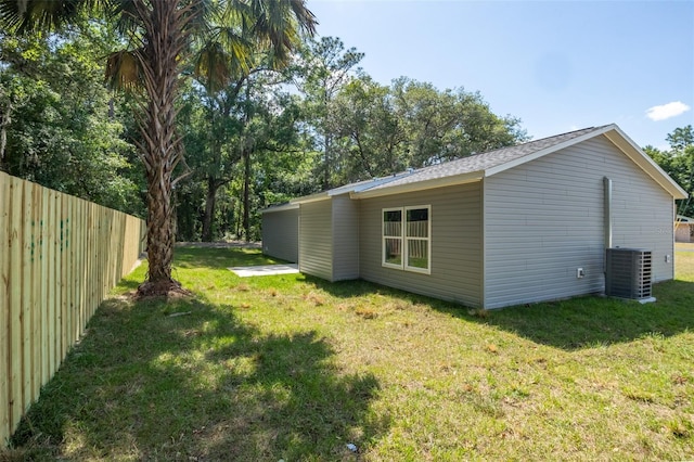 view of home's exterior with a lawn and central AC