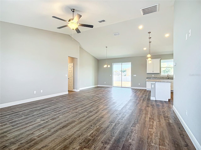 unfurnished living room featuring dark wood-type flooring, ceiling fan, sink, and vaulted ceiling