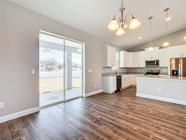 kitchen featuring sink, white cabinetry, hanging light fixtures, stainless steel appliances, and light stone countertops