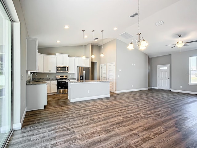 kitchen with white cabinetry, a center island, appliances with stainless steel finishes, dark hardwood / wood-style floors, and pendant lighting