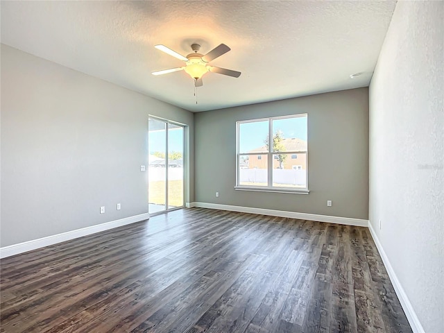 empty room with ceiling fan, dark hardwood / wood-style floors, and a textured ceiling