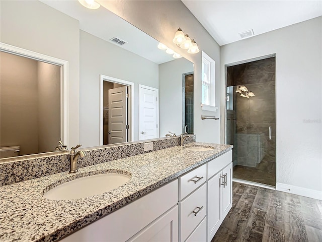 bathroom featuring hardwood / wood-style flooring, vanity, and walk in shower