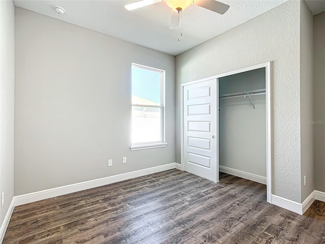 unfurnished bedroom with ceiling fan, dark hardwood / wood-style flooring, and a closet