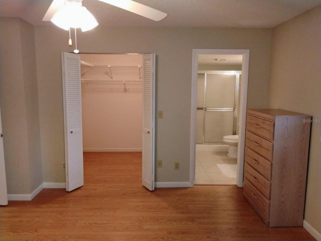 unfurnished bedroom featuring ceiling fan, connected bathroom, and light wood-type flooring