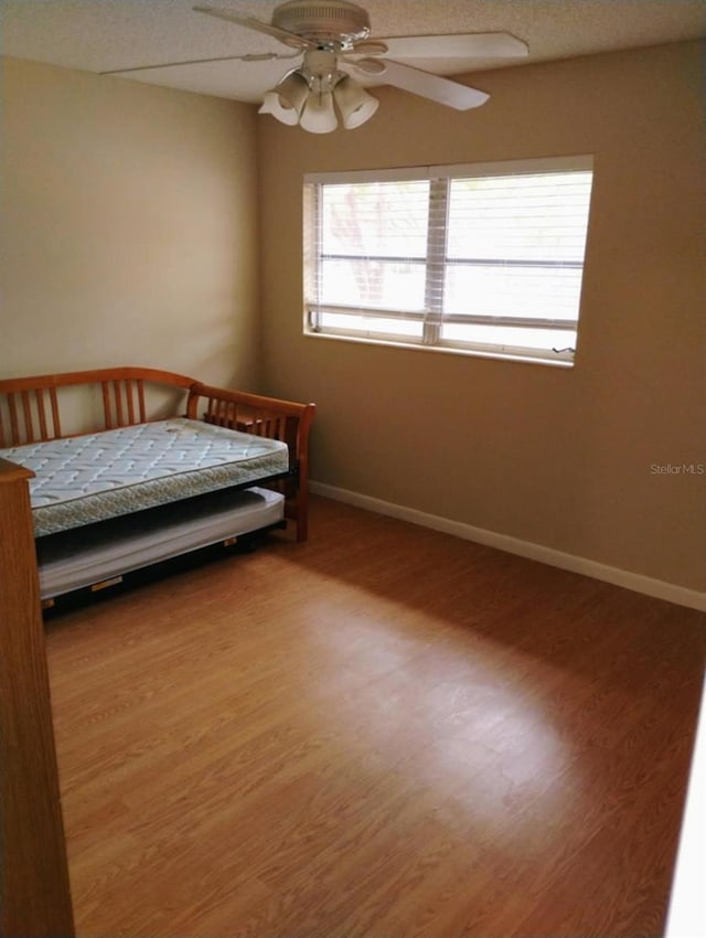 unfurnished bedroom featuring ceiling fan and wood-type flooring