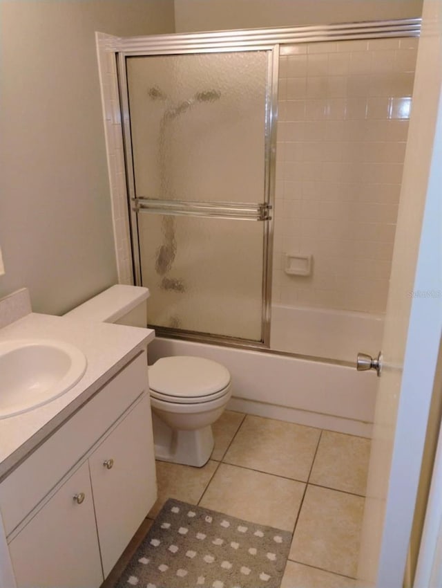 full bathroom featuring toilet, vanity, shower / bath combination with glass door, and tile patterned flooring