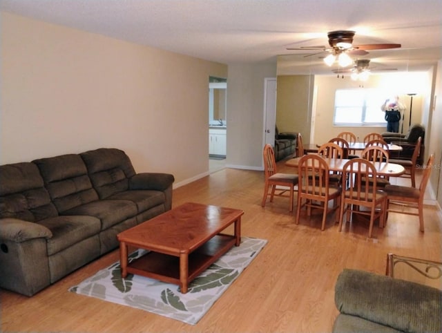 living room featuring ceiling fan and light hardwood / wood-style flooring