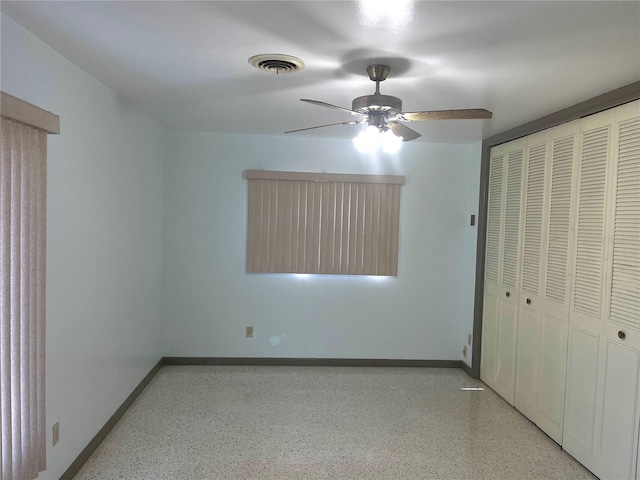 unfurnished bedroom with ceiling fan and a closet