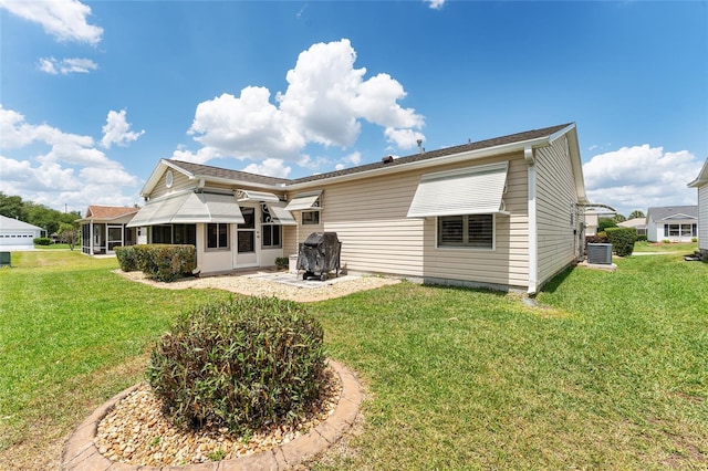 back of property with a patio area, a sunroom, a yard, and central air condition unit