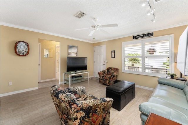 living room featuring a textured ceiling, track lighting, ornamental molding, light wood-type flooring, and ceiling fan