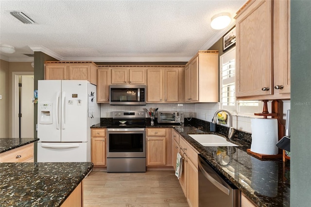 kitchen with decorative backsplash, sink, stainless steel appliances, ornamental molding, and dark stone counters