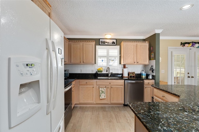 kitchen featuring stainless steel appliances, dark stone countertops, backsplash, and sink