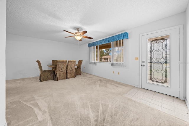 unfurnished room with light carpet, ceiling fan, and a textured ceiling