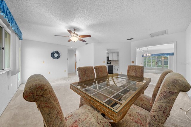 dining area featuring ceiling fan with notable chandelier and a textured ceiling