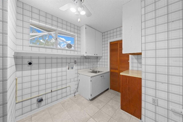 bathroom featuring a textured ceiling, ceiling fan, tile patterned floors, and sink