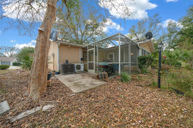 rear view of house with a lanai, ac unit, central air condition unit, and a patio