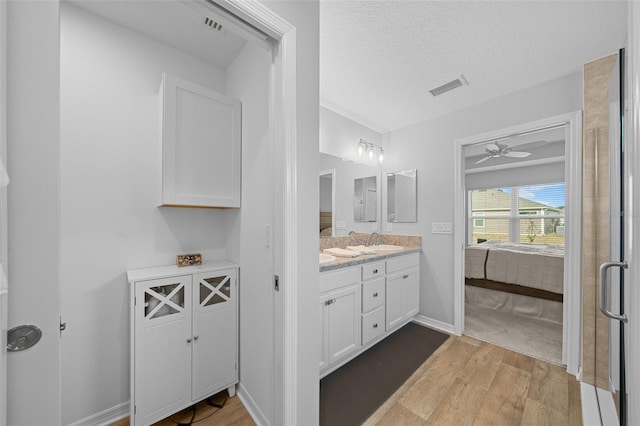 bathroom featuring a textured ceiling, ceiling fan, hardwood / wood-style floors, and vanity