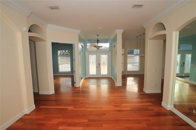 interior space with crown molding, dark wood-type flooring, and french doors